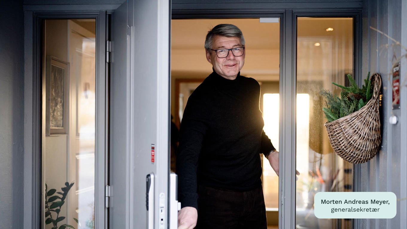 Morten Andreas Meyer, generalsekretær i Huseierne, står i en døråpning i et hus. Han smiler mens han er i ferd med å åpne døren.