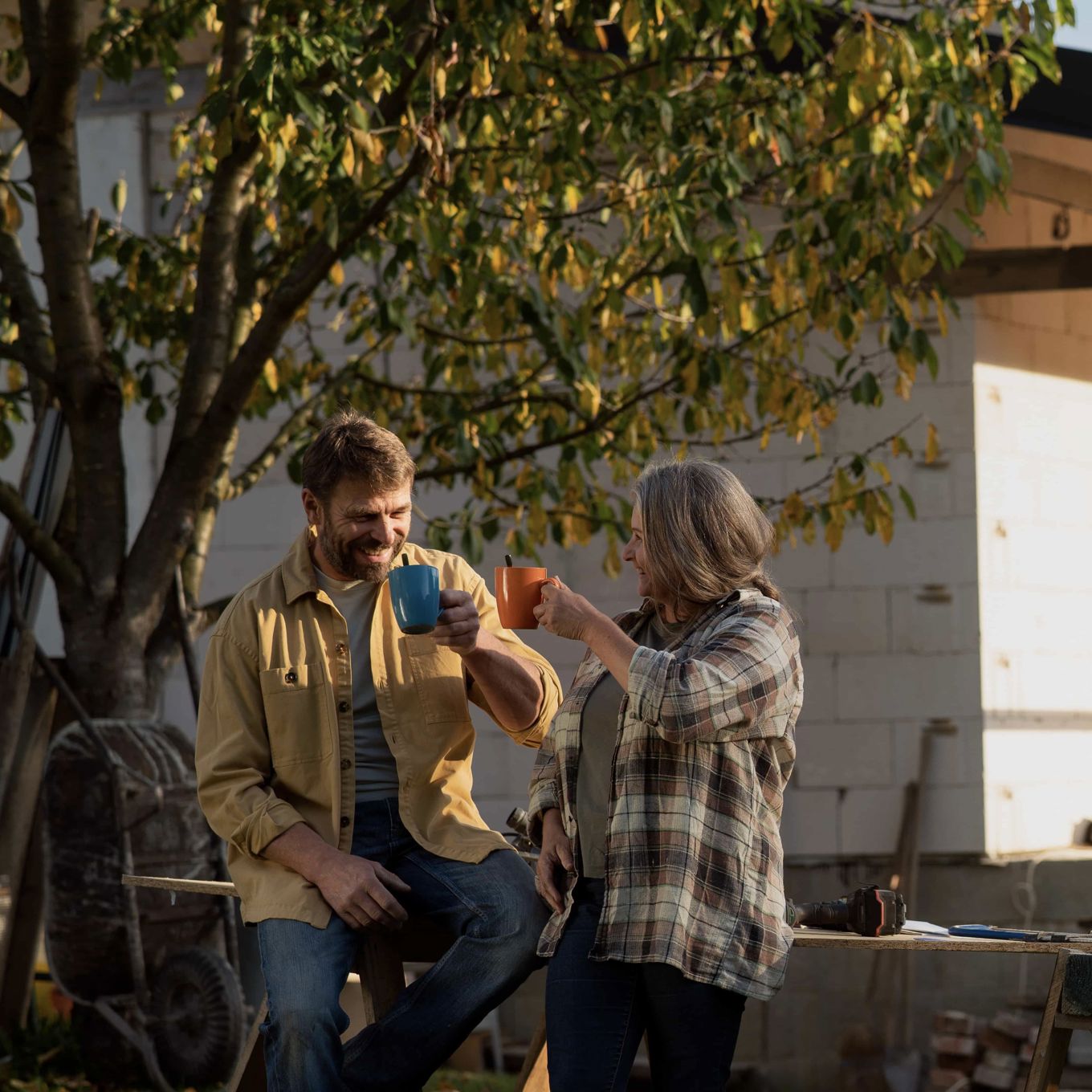 To personer som tar en kaffe og jobber i hagen